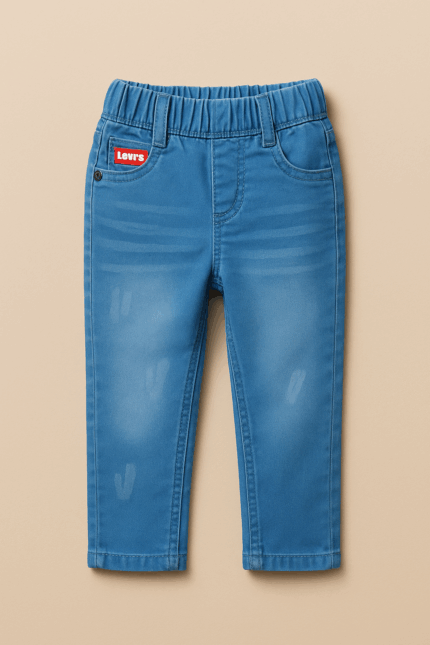 A pair of boys' light blue denim jeans with a slight fade, featuring a red tag near the waistband and visible stitching details.
