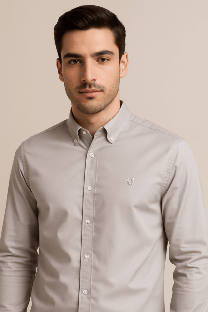 AÂ light-colored, possibly beige or light grey, long-sleeved cotton shirt with a button-down collar and buttoned cuffs.