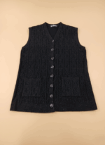 Women's black cable knit sweater vest with buttons and pockets on a beige background