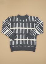 Boy wearing striped winter sweater with jeans and sneakers.