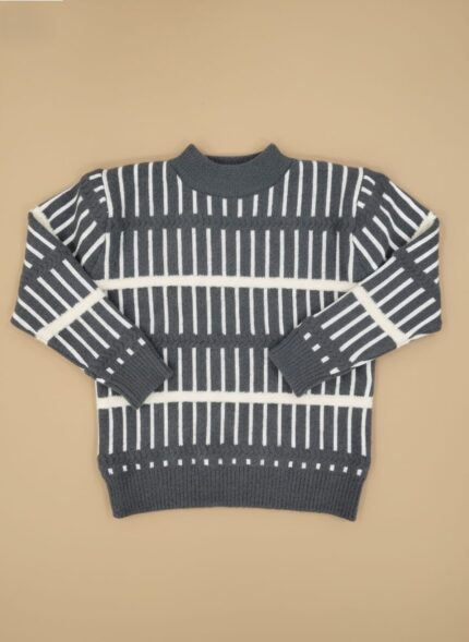 Boy wearing striped winter sweater with jeans and sneakers.