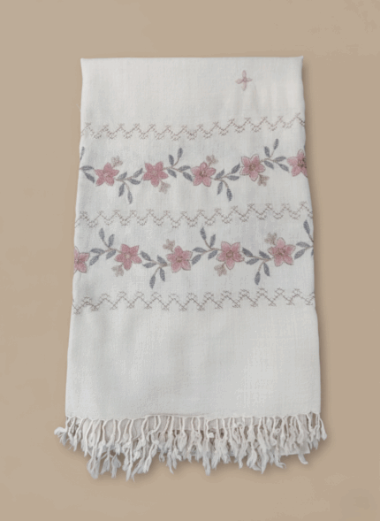 Hand-embroidered floral shawl made from a soft pashmina blend, featuring pink flowers, grey leaves, chevron patterns, and fringed edges on an off-white fabric.