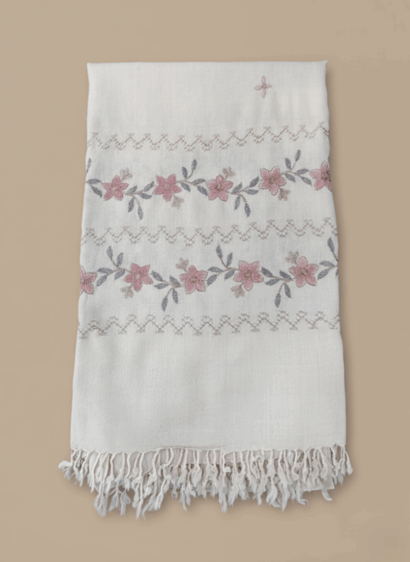 Hand-embroidered floral shawl made from a soft pashmina blend, featuring pink flowers, grey leaves, chevron patterns, and fringed edges on an off-white fabric.