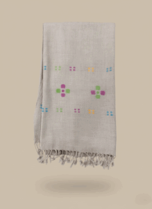 Handloom linen shawl with colorful floral embroidery on a light background.