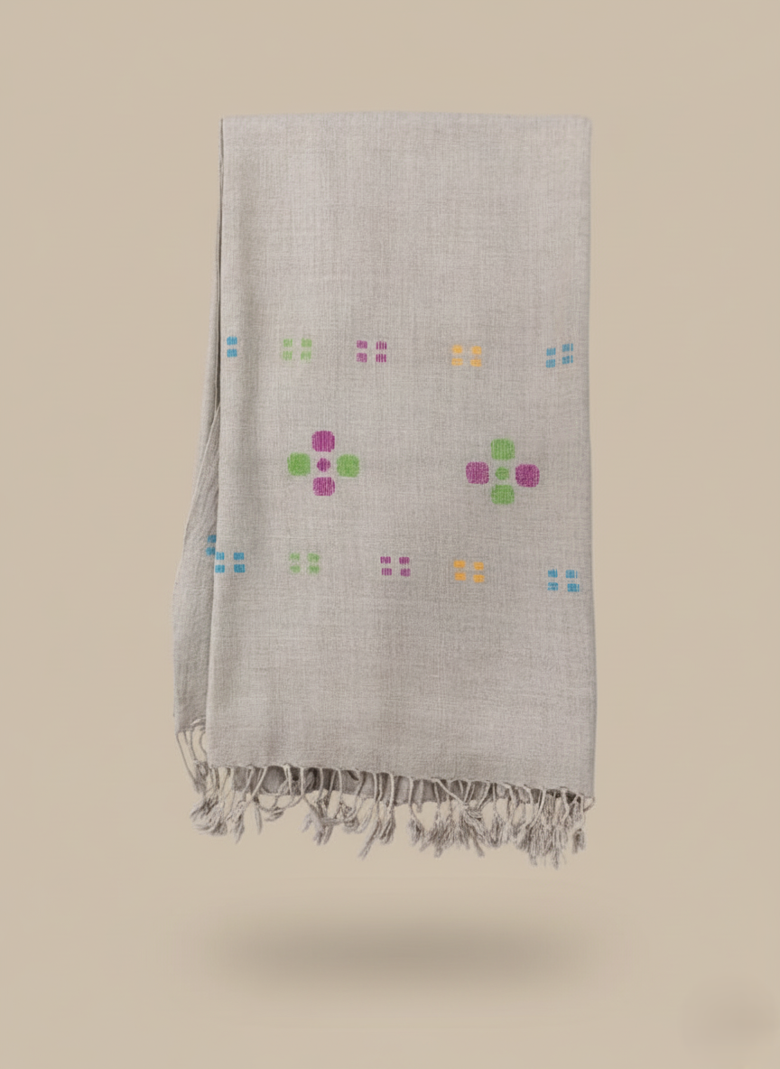 Handloom linen shawl with colorful floral embroidery on a light background.