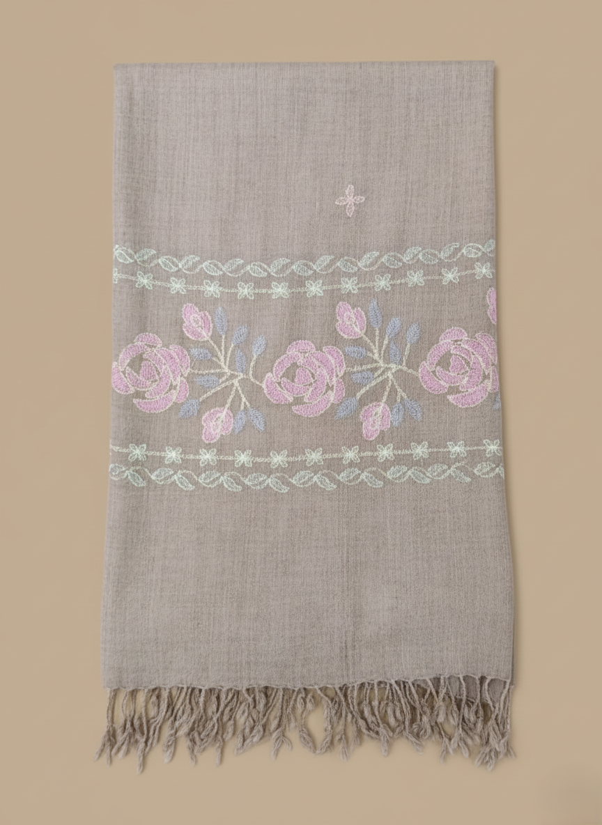 Hand-embroidered pashmina shawl with pink and blue floral embroidery on a beige background and fringed edges.