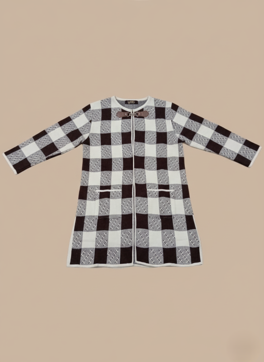 Women's black and white plaid knit sweater with a checkered pattern, long sleeves, toggle closure, and front pockets, displayed against a light brown background.