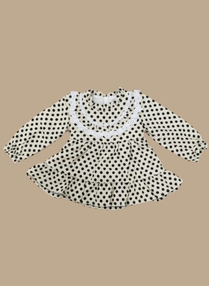 Flat lay of a black and white baby polka dot dress with a white lace Peter Pan collar and ruffled hem.