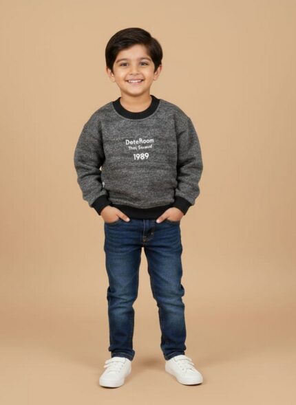 Boy wearing a grey kids sweater with black neckline, cuffs, and “DoteRoom 1989” text on the front.