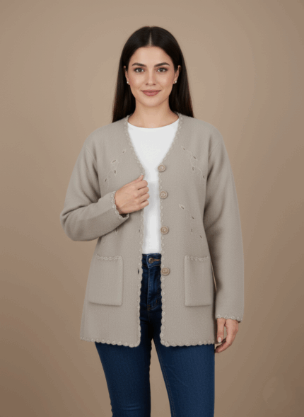 Light beige women's button-front sweater with decorative embroidery, two front pockets, and scalloped edges on a neutral background.