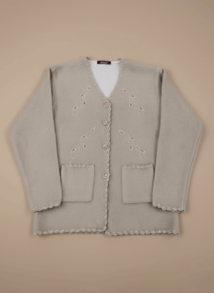 Light beige women's button-front sweater with decorative embroidery, two front pockets, and scalloped edges on a neutral background.