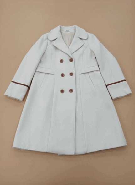 White double-breasted women's coat with brown buttons and sleeve accents, elegant long-sleeve outerwear for women.