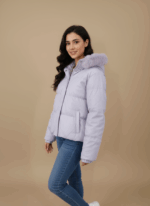 Women's lilac puffer jacket with a faux fur-trimmed hood and cropped length, lying flat on a beige background.