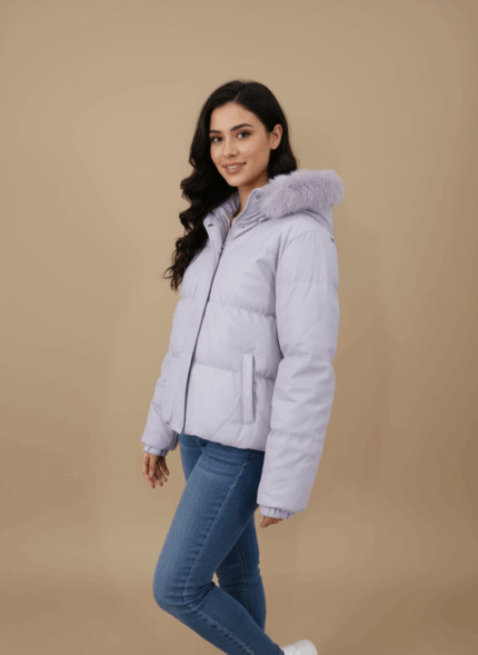Women's lilac puffer jacket with a faux fur-trimmed hood and cropped length, lying flat on a beige background.