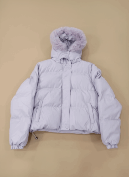 Women's lilac puffer jacket with a faux fur-trimmed hood and cropped length, lying flat on a beige background.
