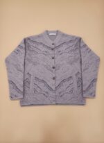 Women's lavender patterned knit cardigan sweater with grey abstract pattern, button front, and front pockets, displayed on a light background.