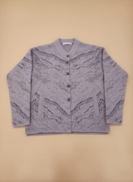 Women's lavender patterned knit cardigan sweater with grey abstract pattern, button front, and front pockets, displayed on a light background.