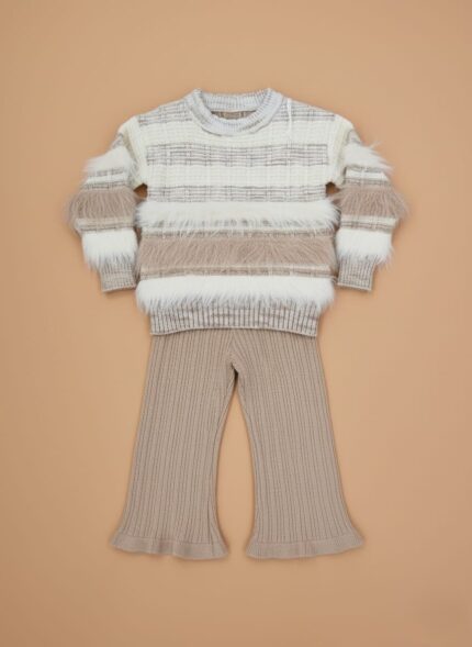 Smiling girl wearing a beige and white fuzzy knit sweater set for winter.