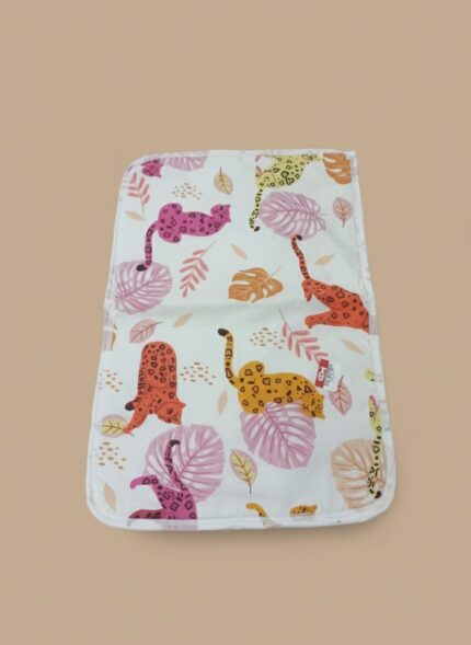 A white cotton baby bib with a vibrant pattern of colorful leopards and tropical leaves.