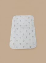 A white baby swaddle blanket featuring a pattern of small grey anchors, laid flat on a light brown background.