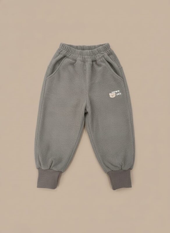 A pair of grey ribbed baby pants with a bear embroidery on the pocket, an elastic waist, and cuffed ankles.