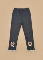 A pair of dark grey ribbed baby leggings with brown bows, white pom-poms, and ruffled white stitching on the ankles.