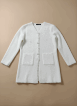 Women's elegant white fuzzy cardigan sweater with pearl buttons, V-neck, long sleeves, and two front pockets, displayed on a beige surface.
