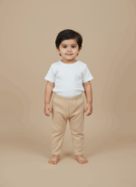 A smiling toddler wearing a white short-sleeve top and beige baby pants, standing on a light brown background.