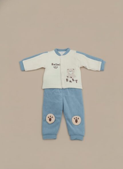 Baby wearing a cream and blue sweater with a bear and "Hello Baby!" text, paired with matching blue pants featuring paw print knee patches.