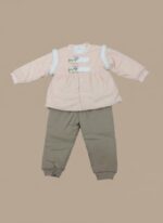 A smiling baby sitting and wearing a pink long-sleeve sweater featuring decorative cat-face buttons and white faux-fur shoulder accents, paired with mocha-colored jogger pants. This is the Baby Cat Detail Sweater Set.