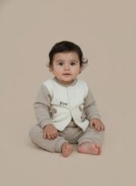 Baby wearing a beige and cream ribbed winter sweater set with puppy embroidery, sitting on a light background.