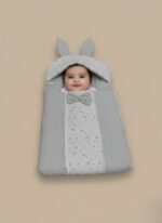 Grey baby sleeping bag with star print, bunny ears, and a bow on a neutral background.