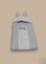 Grey baby sleeping bag with star print, bunny ears, and a bow on a neutral background.