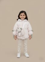 Pink kids puffer jacket with a light pink main color, green and white gingham accents on the hood and cuffs, and a padded frog-shaped crossbody bag attached to the front. The jacket has a hood, full front closure, and a gathered waist.