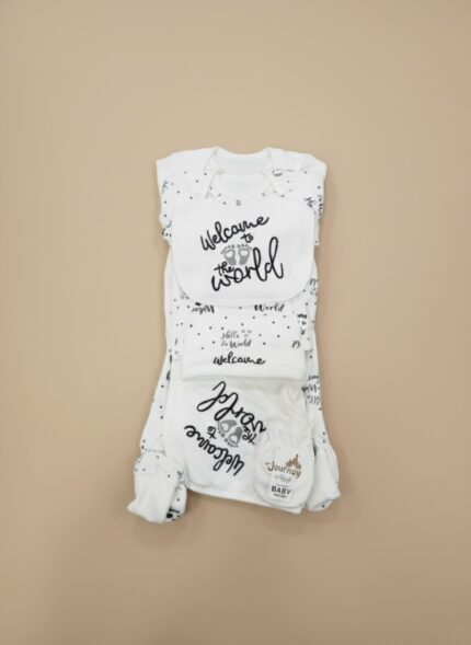 Lay-flat studio shot of the complete "Welcome to the World" baby starter outfit set, showing a white and black polka dot onesie, pants, bib, and knotted hat, laid out neatly.