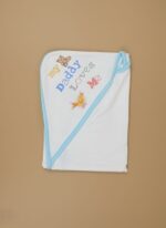 A newborn baby swaddled in a white blanket with green trim, featuring "YOU MAKE ME HAPPY" embroidered text, a teddy bear, an owl, and dinosaur patterns.