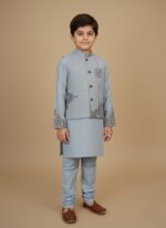 Boy wearing a blue embroidered waistcoat suit with matching kameez shalwar, designed for festive and formal occasions.