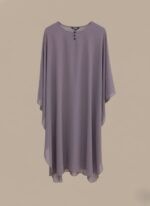 A woman wearing a full-length lavender kaftan abaya with batwing sleeves and a round neckline with small buttons.