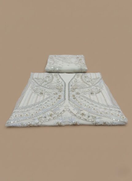 A flat-lay image of the Claire Price UNSTITCHED three-piece suit in off-white/ivory Organza, heavily decorated with silver and champagne embroidery and embellishments, alongside the matching raw silk trouser and slip fabric. Ideal for formal and party wear.