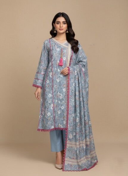 A woman wearing a soft blue floral printed khaddar Angrakha style suit with a long-sleeved shirt, light blue trousers, and a coordinating printed khaddar dupatta. The suit features white and pink floral prints and pink lace trim.