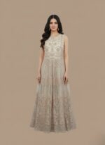 Sleeveless embroidered beige net maxi dress with intricate patterns on a neutral background.