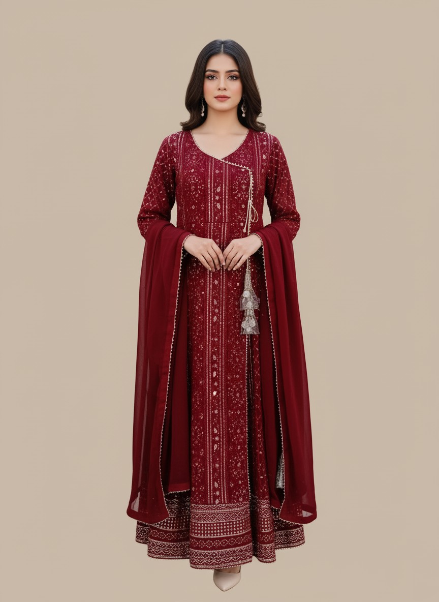 Elegant Maroon Printed Chiffon Anarkali Suit A woman wearing a vibrant maroon printed chiffon Anarkali style suit with a long-sleeved, flared kurta, matching maroon trousers, and a coordinating chiffon dupatta. The suit has intricate gold and silver prints and a decorative tassel.
