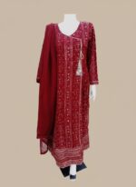 A model elegantly showcases the stunning maroon printed chiffon Anarkali suit, featuring intricate metallic patterns, a flowing silhouette, and a delicate tassel on the neckline. Alt Text (for Image 1 - model wearing suit): A woman weari