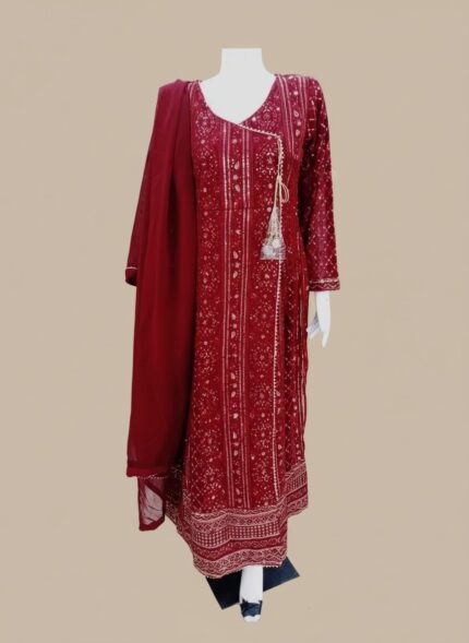 A model elegantly showcases the stunning maroon printed chiffon Anarkali suit, featuring intricate metallic patterns, a flowing silhouette, and a delicate tassel on the neckline. Alt Text (for Image 1 - model wearing suit): A woman weari