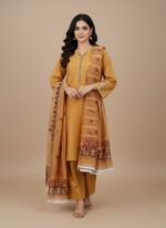 Full-length view of a woman wearing a mustard embroidered cotton kurta set with a printed dupatta and matching trousers.
