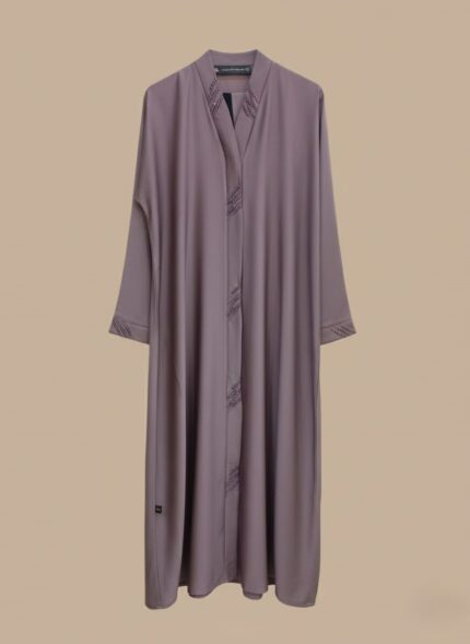 Woman wearing a soft mauve premium abaya with embroidered front design and matching scarf.