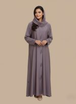 Woman wearing a soft mauve premium abaya with embroidered front design and matching scarf.