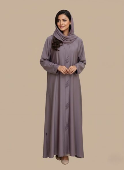Woman wearing a soft mauve premium abaya with embroidered front design and matching scarf.