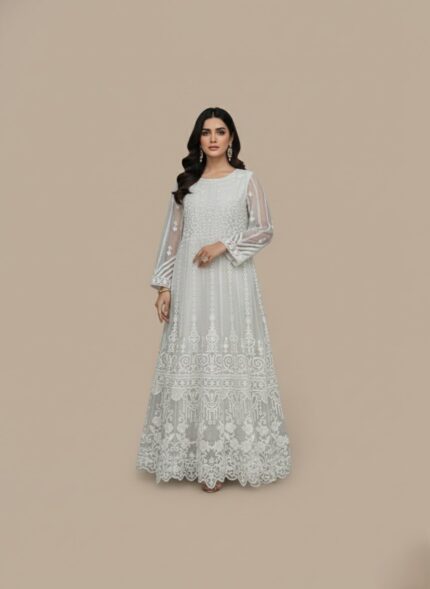 White embroidered net maxi dress with intricate design and a flowing silhouette, next to folded plain white fabric.