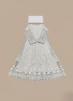 White embroidered net maxi dress with intricate design and a flowing silhouette, next to folded plain white fabric.